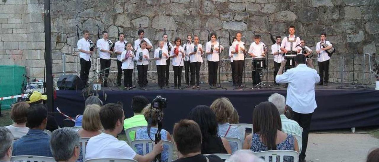 Banda &quot;Devandoira&quot; de Lugo, durante la actuación bajo el Puente Romano. // Iñaki Osorio