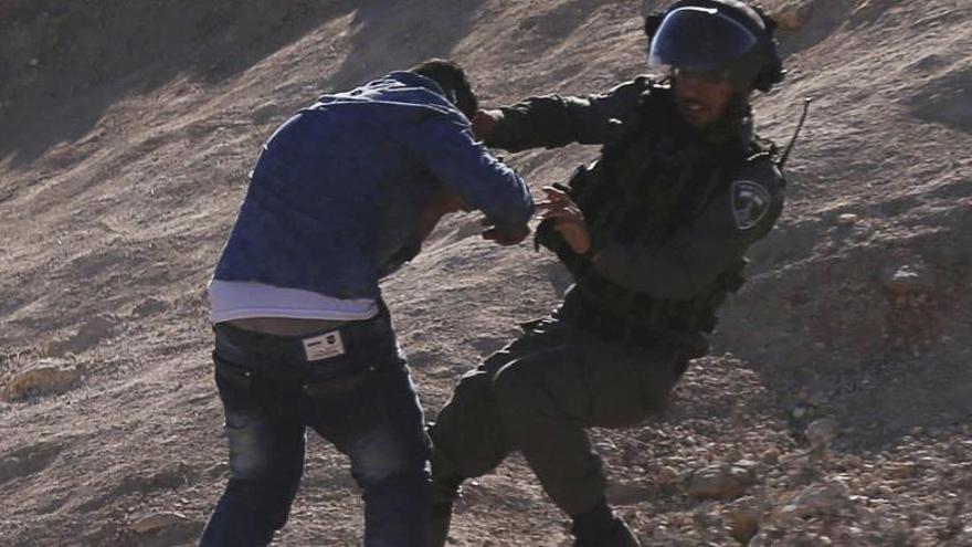 Un agente israelí forcejea con un palestino en Tulkarem.