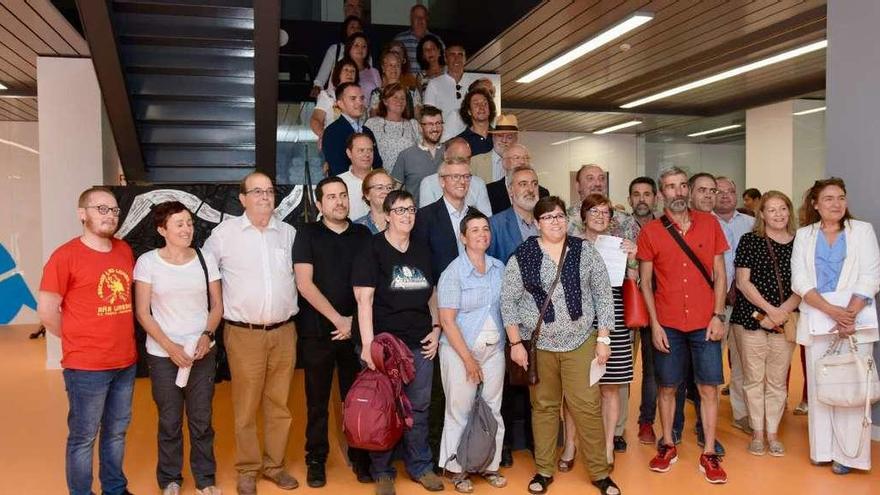 Foto &quot;de familia&quot; de las asociaciones que estrenan sede en el edificio de Benito Corbal con el vicepresidente de la Xunta. // Rafa Vázquez