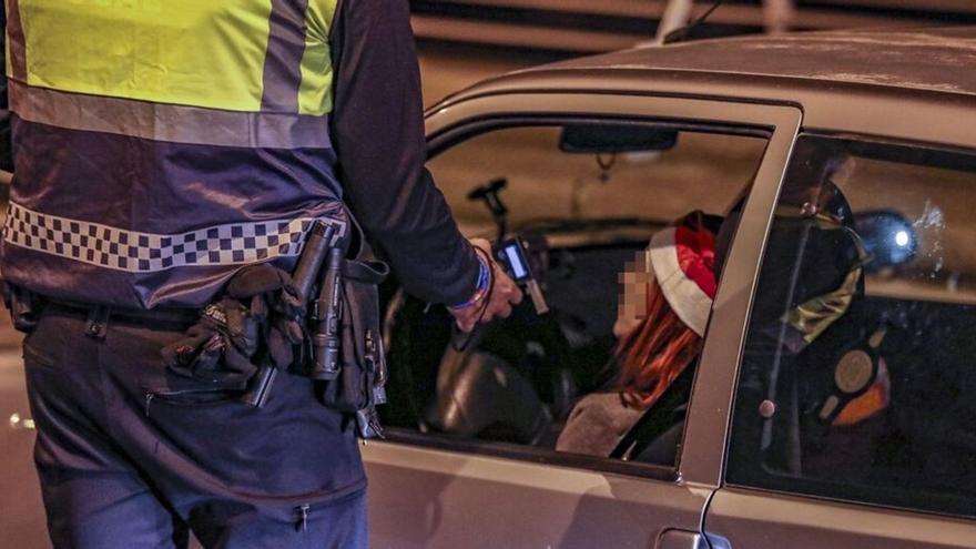 Un policía local de Elche procede a practicar una prueba de alcoholemia a una conductora en un control específico y en fechas navideñas. | ANTONIO AMORÓS