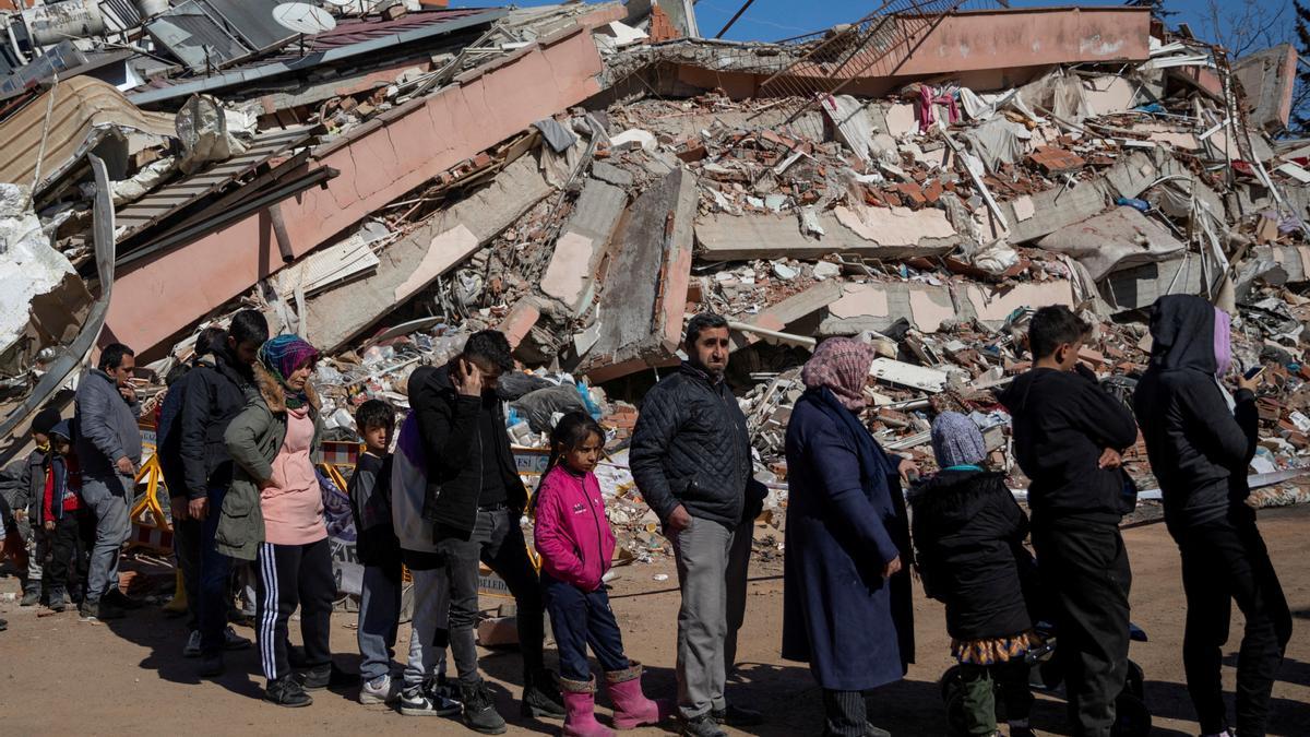 Personas hacen cola para recibir comida gratuita servida entre los escombros tras el mortífero terremoto en Kahramanmaras, Turquía.