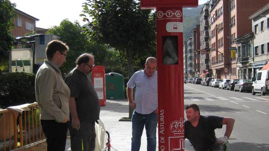 Enrique Fernández, a la izquierda, supervisa la instalación de un poste.