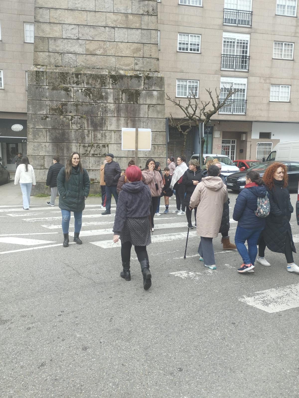 Unos vecinos interrumpen el tráfico en un paso de peatones como protesta.