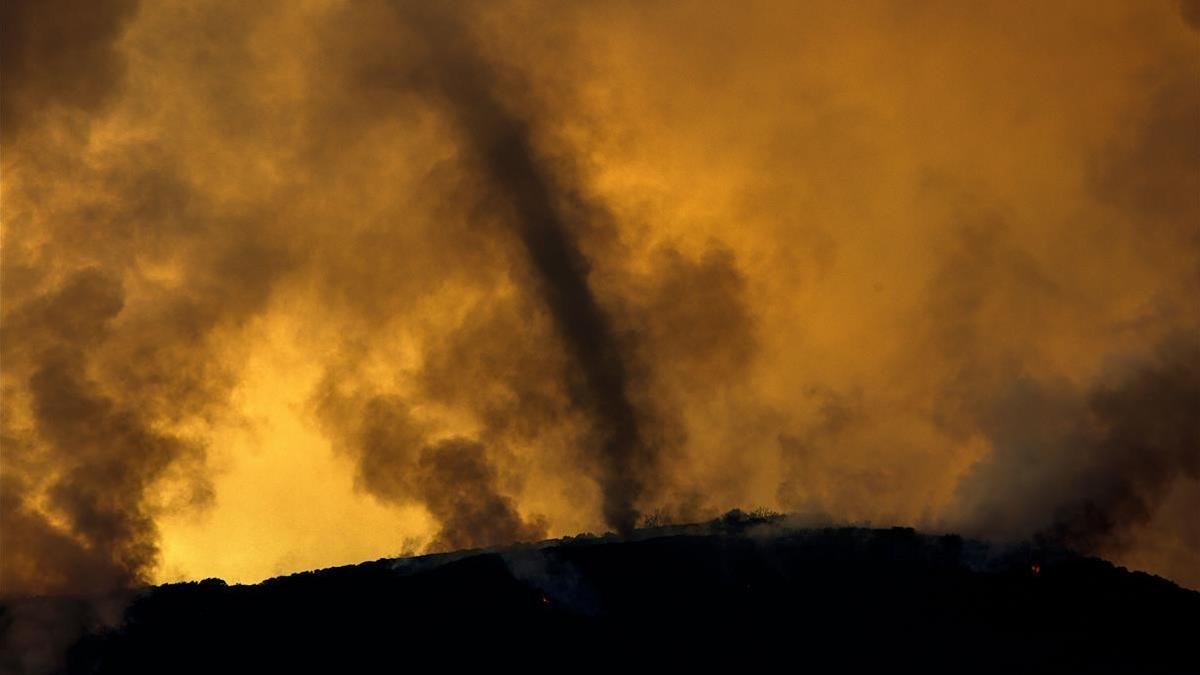 Un remolino de cenizas en el fuego Holy que quema el sur de California.