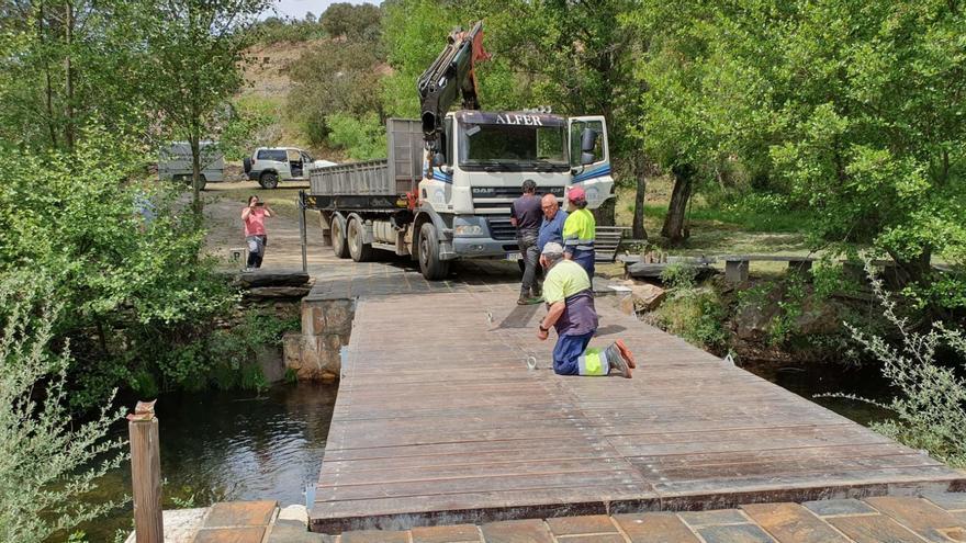 Operarios del Ayuntamiento de Figueruela de Arriba proceden a colocar el puente que tan solo se utiliza durante un día al año, con motivo de la celebración de la romería de la Virgen de Fátima que tendrá lugar este domingo.  | Chany Sebastián