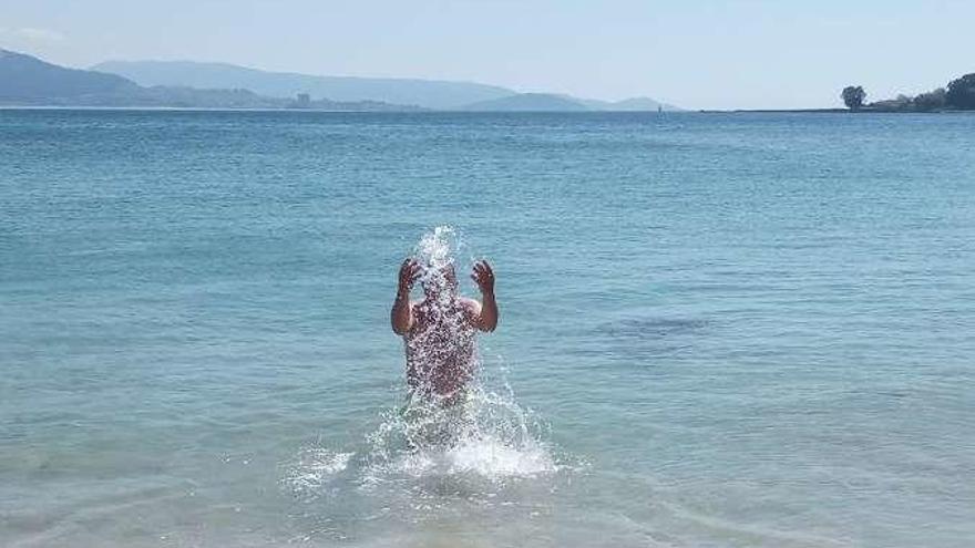 Un vecino en Rodeira, en Cangas, disfruta del primer baño. // S.Á.