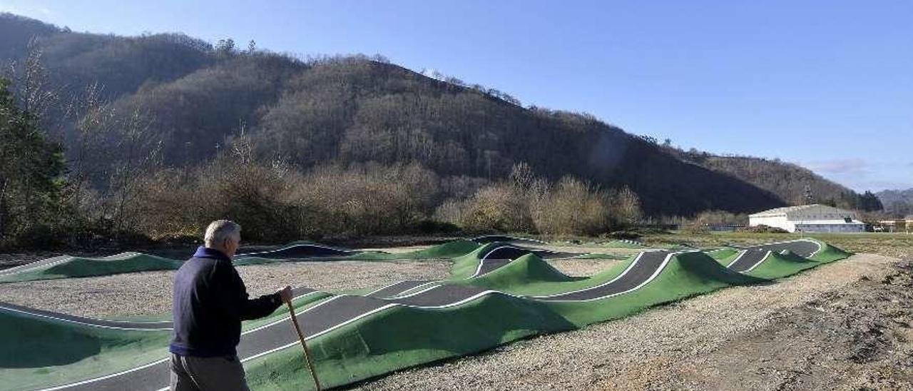 Un vecino camina junto a las obras del &quot;pumptrack&quot; de Barredos.