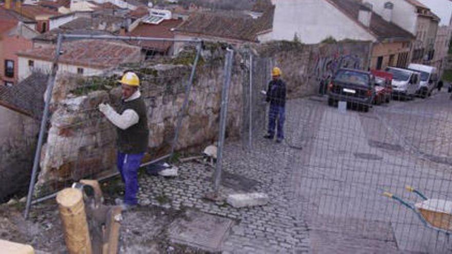 Varios operarios iniciaron ayer los trabajos de desmontaje de la valla para reparar el tramo de muro.