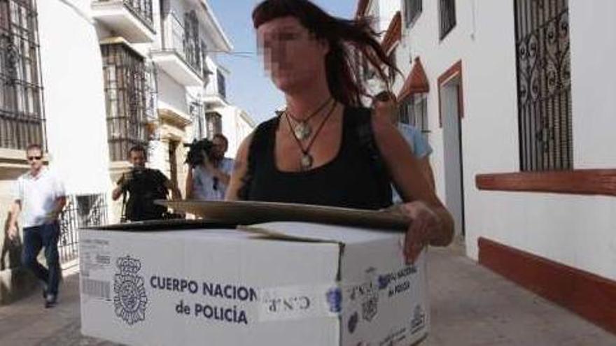Una agente lleva documentación intervenida en el Ayuntamiento de Ronda.