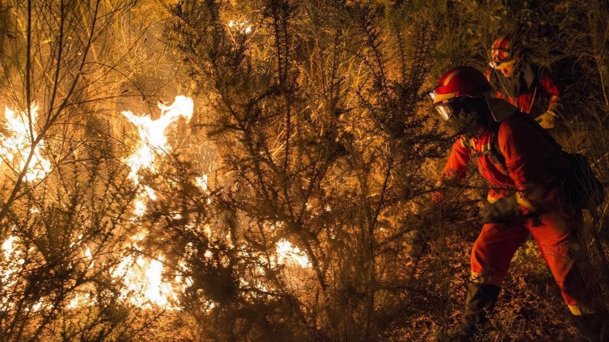 Unos bomberos luchan contra el fuego en Vilamarin, en Galicia