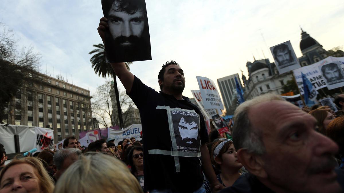 A man holds up a portrait of Maldonado, a protester who has been missing, during a demonstration to demand actions to find him in Buenos Aires