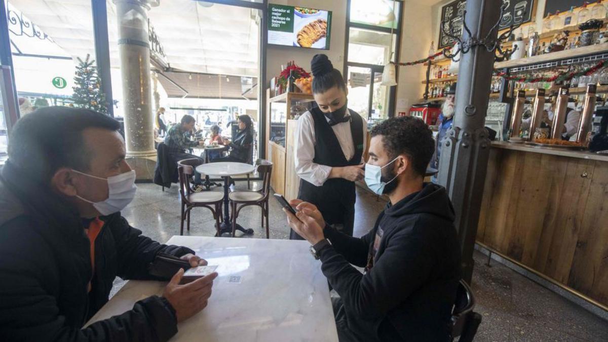 Un joven muestra el certificado en el bar Cristal. | G.BOSCH