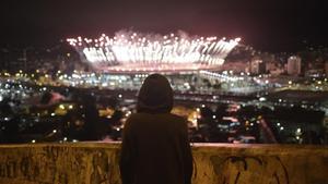 Un niño observa desde el Morro da Mangueira los fuegos artificiales de Maracaná durante la ceremonia de clausura de los Juegos.