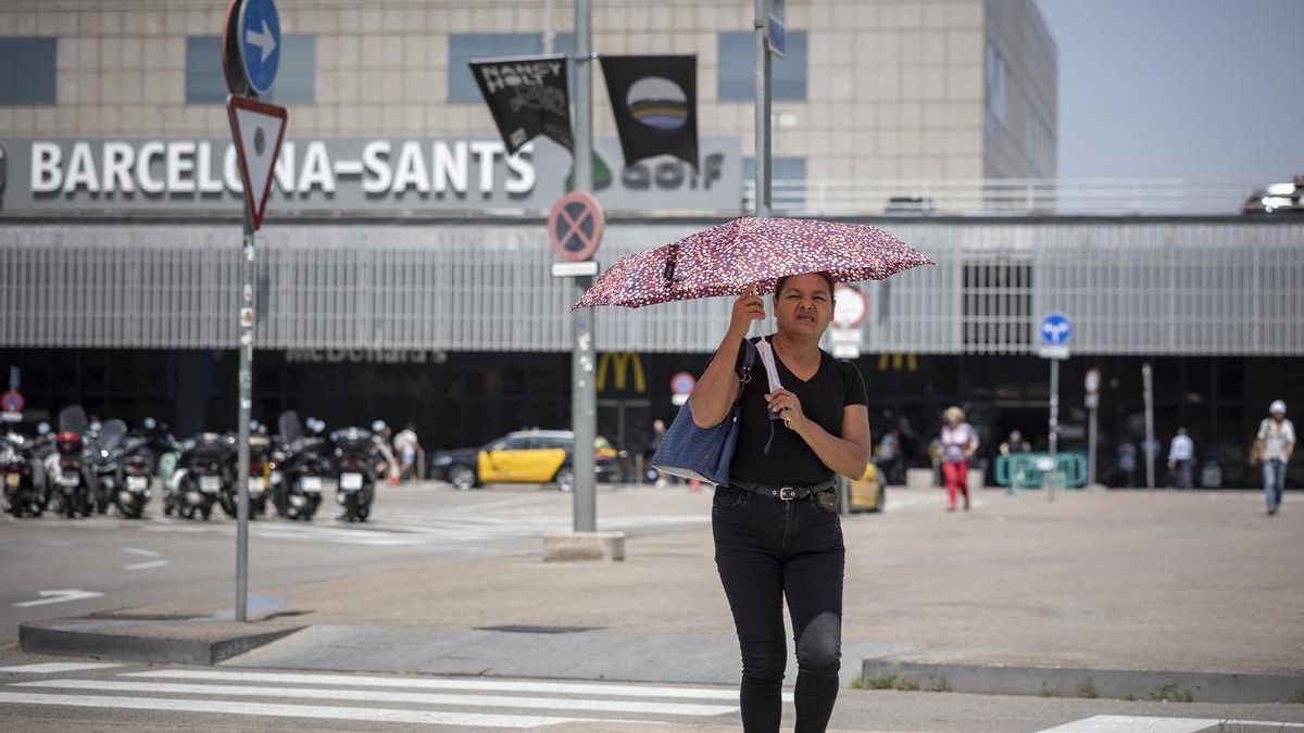 Una persona se refugia del sol durante un episodio de calor en Barcelona.