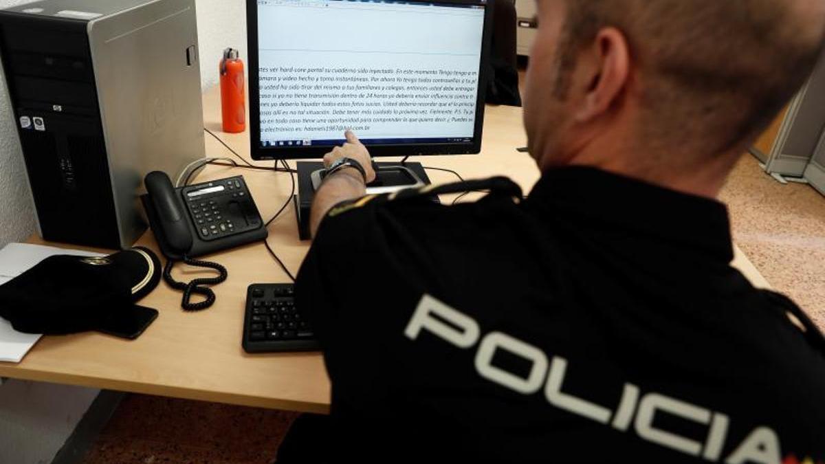 Un policía nacional revisa los mensajes de un caso de sextorsión.