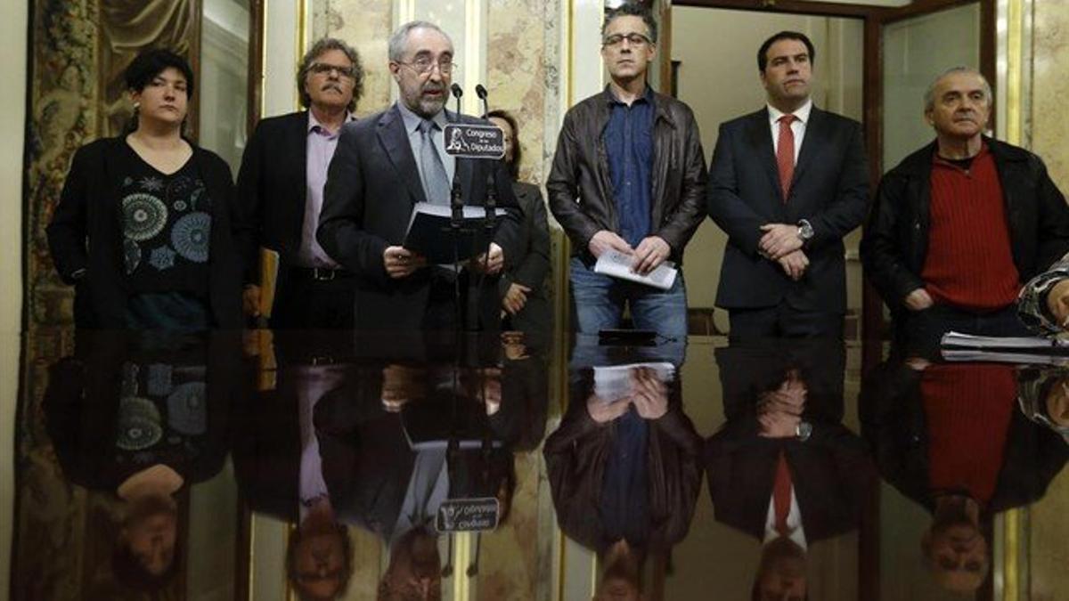 El diputado de Amaiur Rafael Larreina, ante el micrófono, junto a representantes de ERC y el BNG, lee el manifiesto a favor del cierre de la causa de las 'herriko tabernas'. EFE / JUAN CARLOS HIDALGO