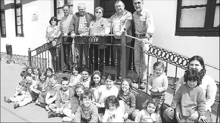 Varios vecinos, miembros de la junta vecinal y la alcaldesa de barrio, ayer, junto a los niños del Colegio de Agones, el futuro del pueblo.