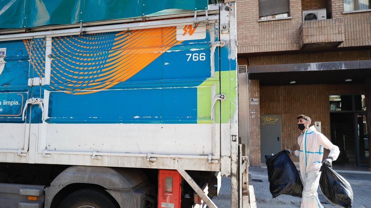 Un operario deposita una bolsa de basura en un camión de SAV.