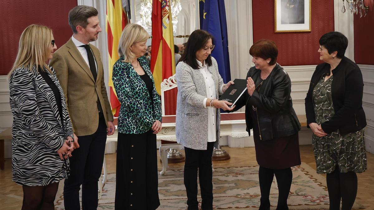 La presidenta de las Corts, Llanos Massó, recibe la memoria de la AVL de manos de su presidenta, Verònica Cantó, en marzo de 2024.