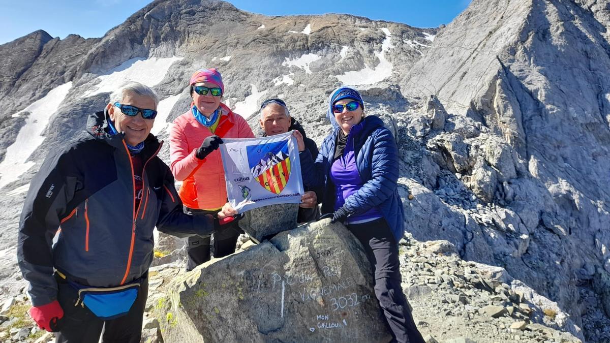 Los cuatro montañeros exhiben la bandera del CETV en los Pirineos