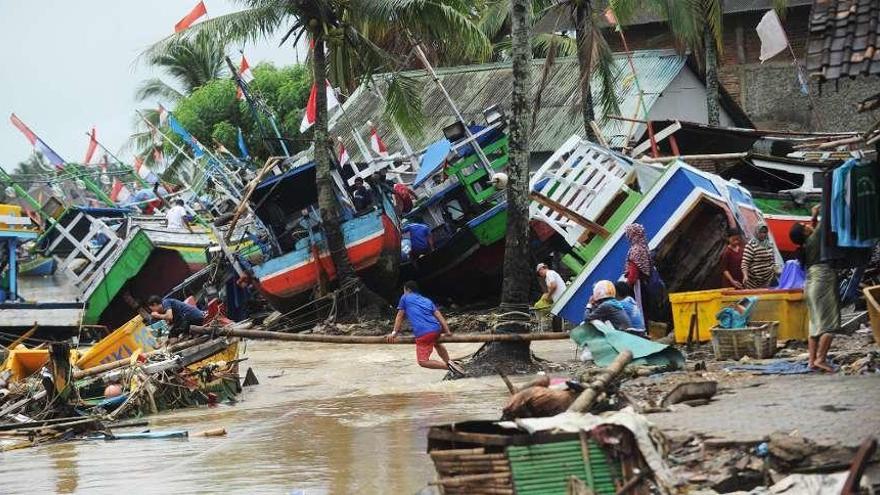 Barcos pesqueros lanzados contra las viviendas en Labuan. // AFP