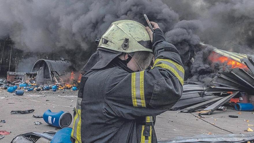 Un bombero trabaja en la extinción del fuego de un almacén de productos químicos bombardeado  en Kiev.