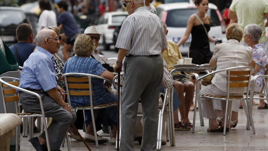 Unos ancianos dialogan en una plaza de Valencia.