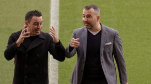Xavi y Diego Martínez charlan en el césped del Camp Nou el día antes del derbi.