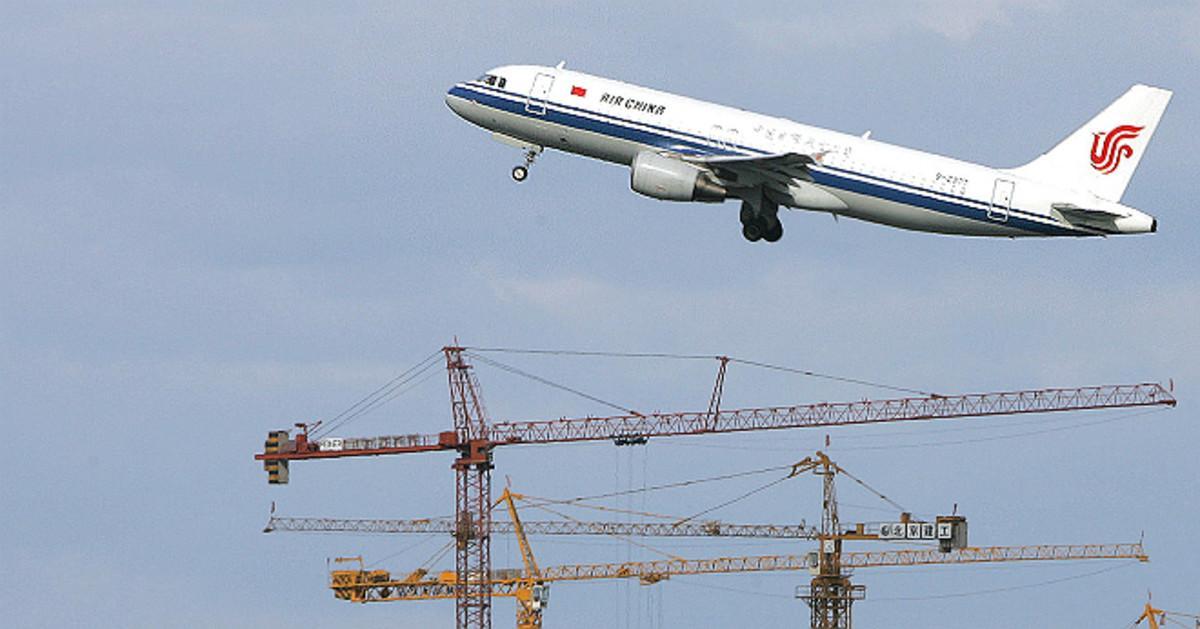 Un avión de Air China sobrevuela unas grúas en Pekín.