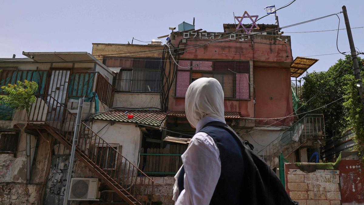 Una niña pasa por delante de una casa ocupada por israelís en el barrio de Sheik Jarrah.