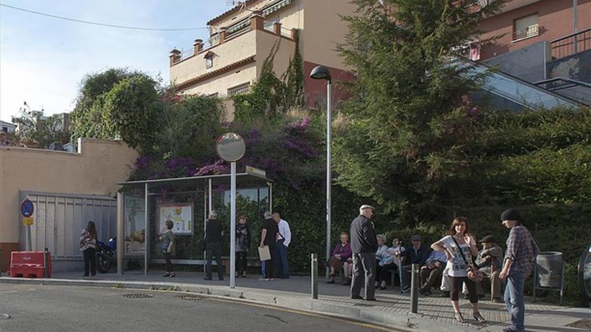 jubilados del barrio sentados junto a la parada del autobús ante la falta de una zona verde