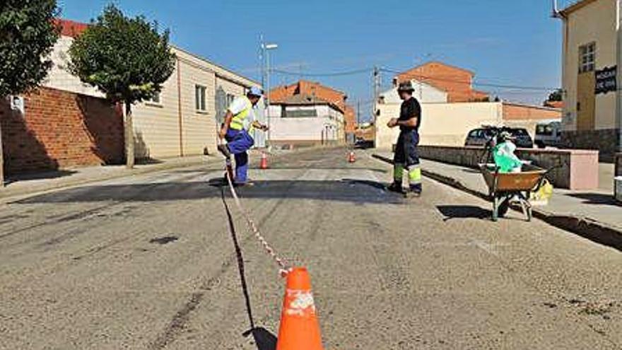 Operarios municipales en una actuación de repintado de un resalte y paso de peatones.