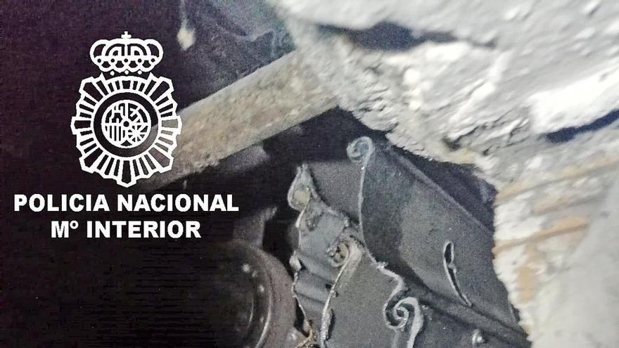 Agujero en la persiana del garaje donde estaba la droga. // Policía