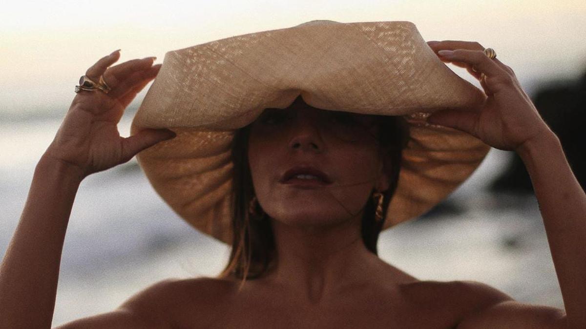 Paula Ordovás con un sombrero de paja para su look de playa.