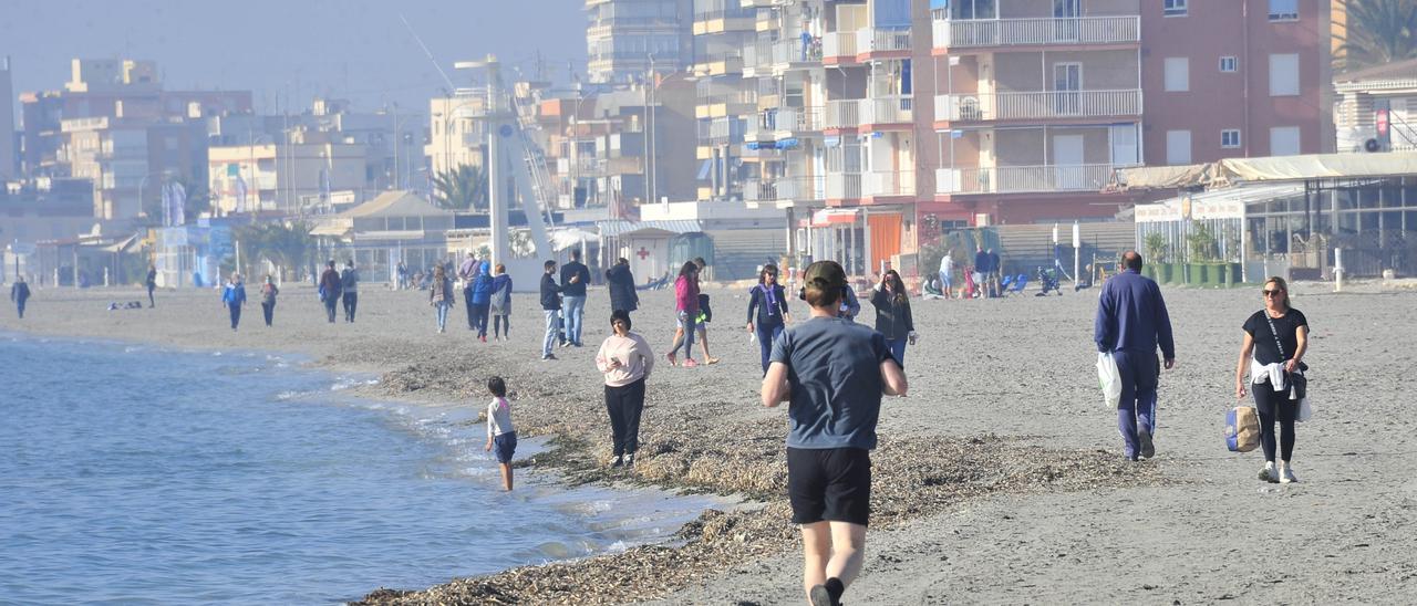 Vecinos y visitantes paseando por Playa Lisa, en Santa Pola