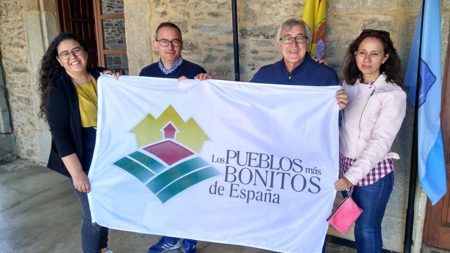 Los responsables municipales y el personal de la oficina de Turismo de Puebla, con la bandera de los Pueblos Más Bonitos de España.