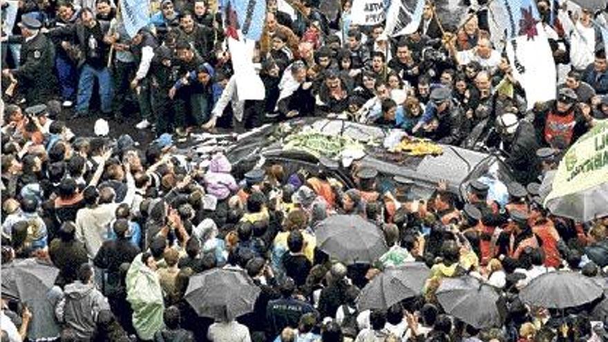 Miles de simpatizantes pugnan por tocar el coche fúnebre con los restos de Kirchner.