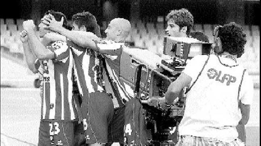 Roberto Canella y Matabuena se abrazan por detrás a Barral tras anotar éste el primer gol del Sporting.