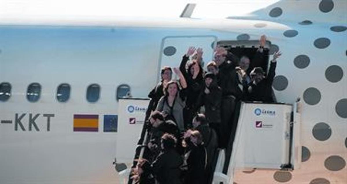 Els passatgers del primer vol d’Alguaire saluden des de l’escaleta de l’avió. Els passatgers del primer vol d’Alguaire saluden des de l’escaleta de l’avió.