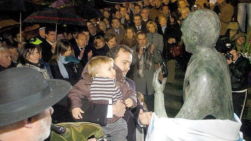 Rafael Cuiña, con su hijo Xosé en brazos, descubre la estatua de su padre en la Praza da Igrexa de Lalín ante la mirada del resto de su familia y el aplauso de todos los presentes