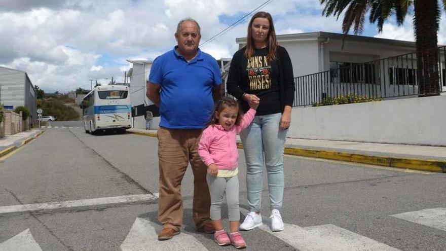 Nélida Vázquez, con su hija pequeña, y otro abuelo que va a buscar a su nieto al CEIP de Carril. // Noé Parga