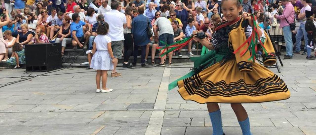 Una niña vestida de aldeana baila al son de la música de los mariachis de México en la plaza de Posada.