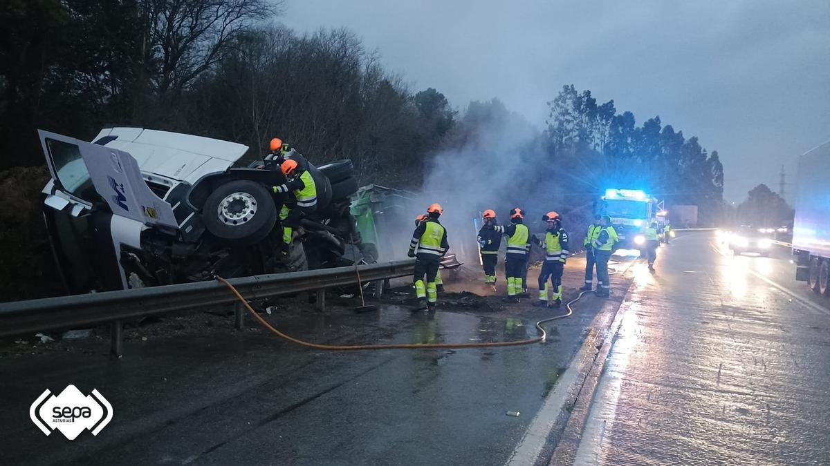 Los Bomberos junto al vehículo siniestrado.