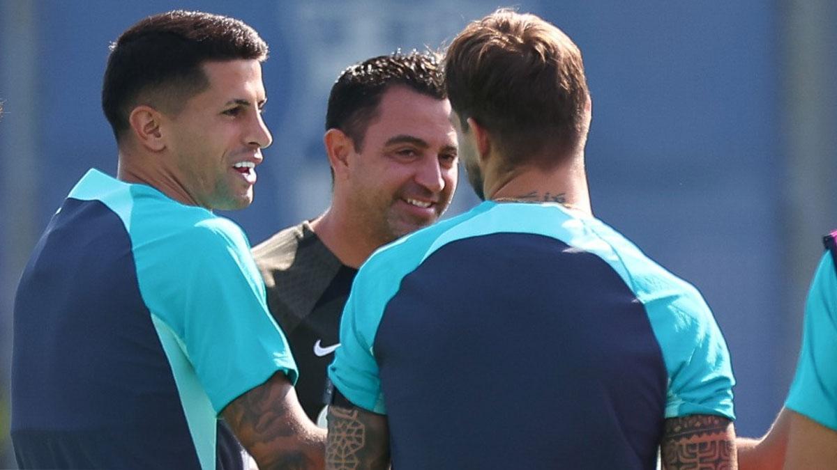 Joao Cancelo, sonriendo junto a Xavi en la sesión previa al FC Barcelona - Royal Amberes