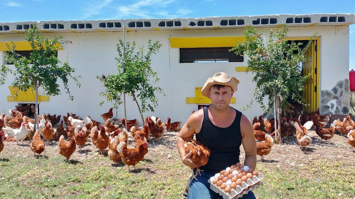 José Manuel Antich posa con los huevos puestos por su gallinas en su corral de Silla.