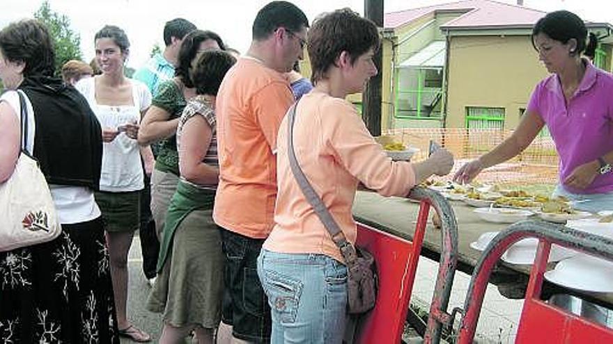 Los vecinos cogen su ración de paella, ayer, en las fiestas del barrio del Casal.