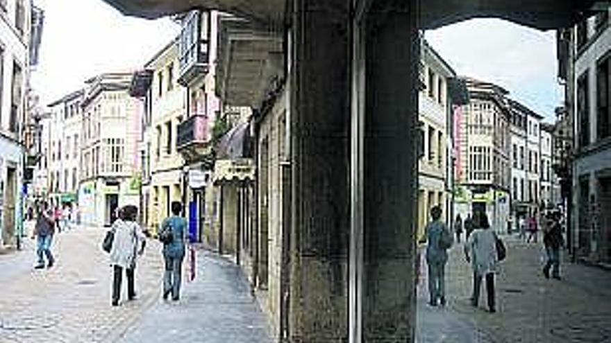 la personalidad. Unas botellas de sidra, emblema de la comarca, en una calle de Villaviciosa, con el teatro Riera asomando al fondo. / miki lópez