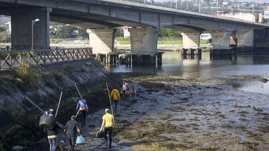 Mariscadores con sus utensilios en la ría de O Burgo.