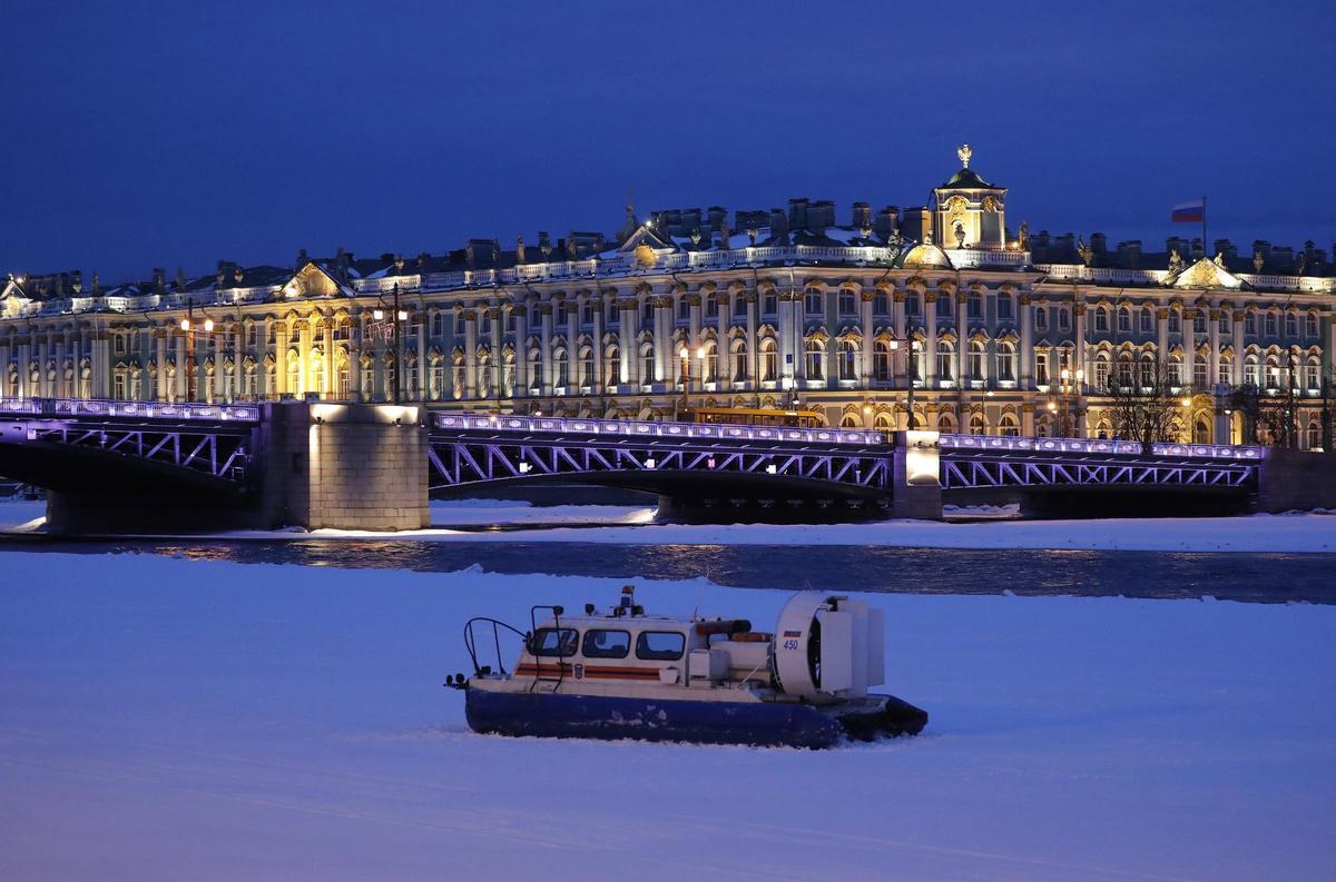 Canales de San Petersburgo helados con el puente Dvortsovy y el palacio de fondo..