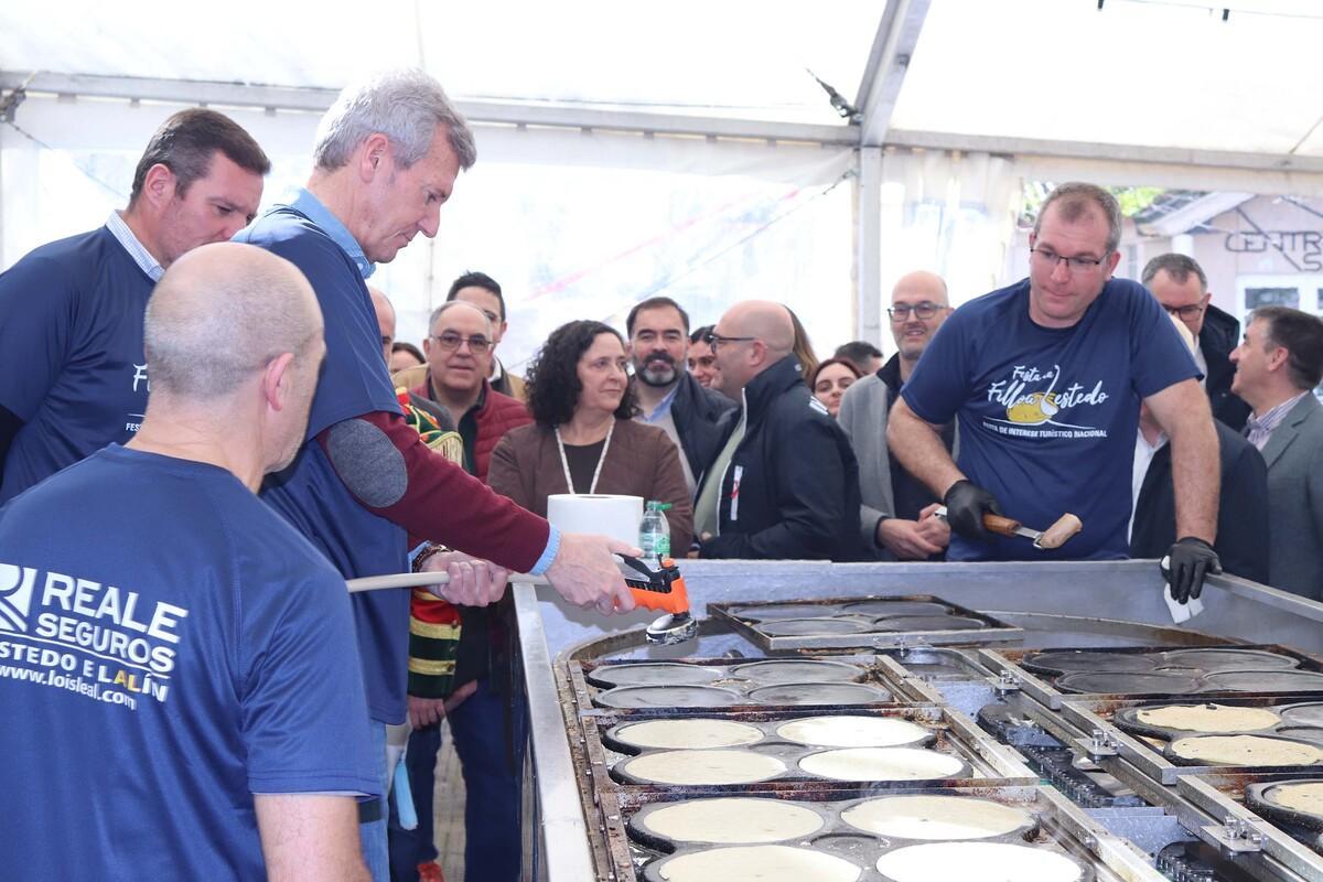 Autoridades preparando filloas en una de las dos máquinas de Lestedo